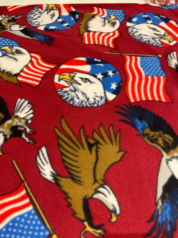Bald eagle patriotic fleece on burgundy background.   60” wide, 100% polyester and $6.99 per yd.