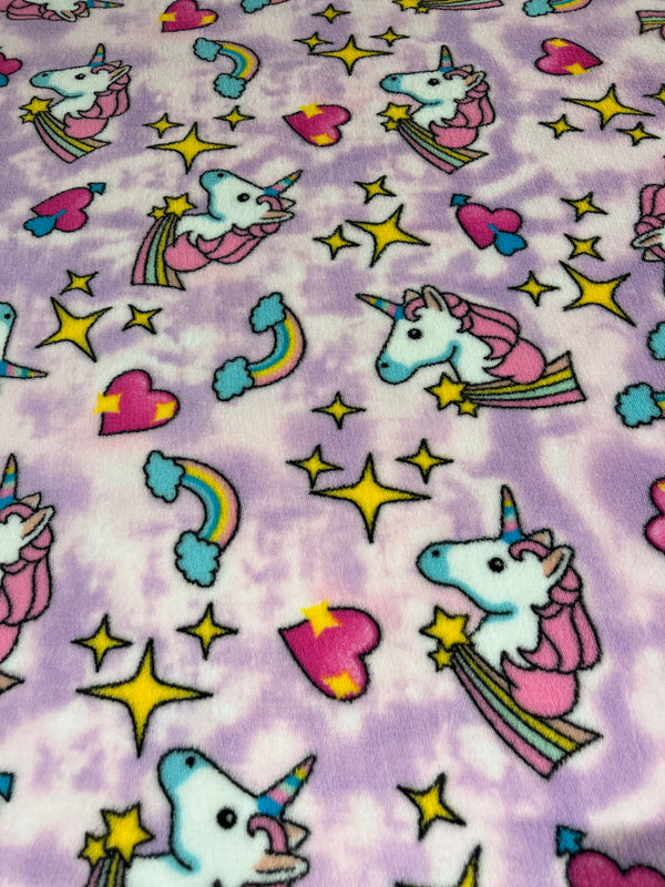 Unicorns & rainbows on purple clouds whisper fleece.   100% polyester, 60” wide and $9.99 per yd.