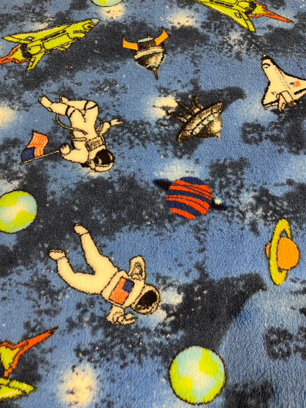 Going to space whisper fleece space themed on blue background.   100% polyester, 60” wide and $9.99 per yd