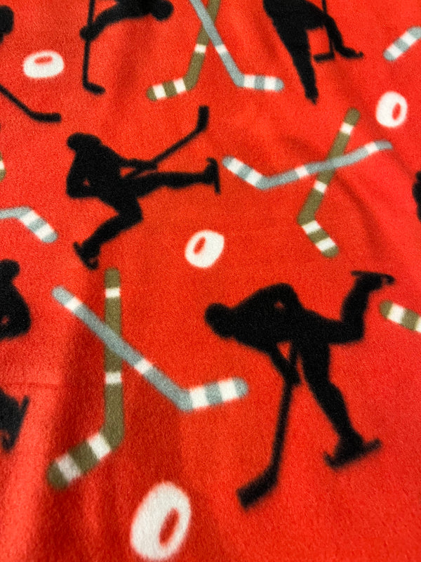 Hockey players on red background.  58” wide, 100 polyester fleece and $6.99 per yd.
