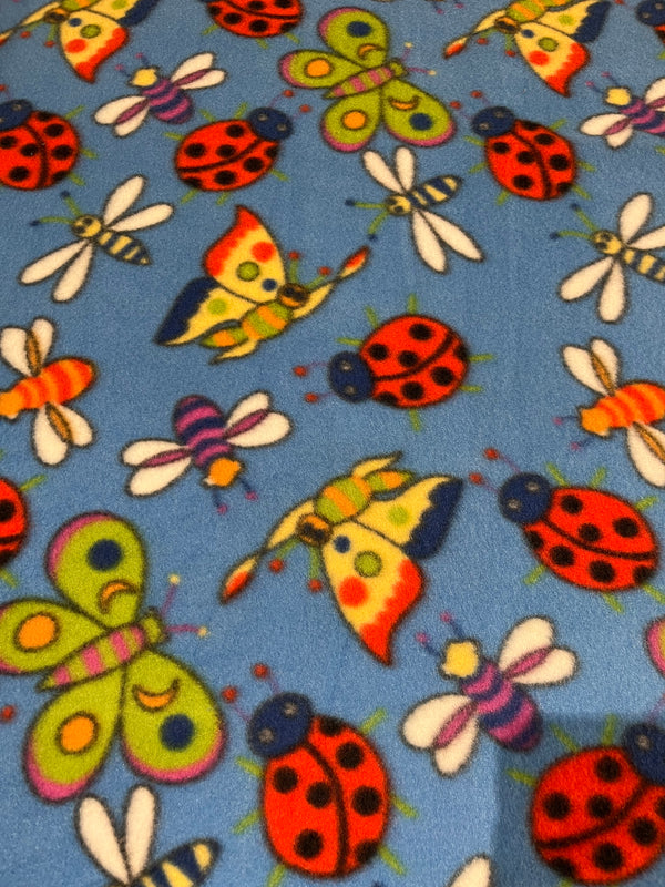 Bug & butterfly fleece.   Primary colored bugs and butterflies on light royal blue background.  58” wide, 100% polyester and $6.99 per yd