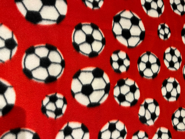 Soccer ball fleece-red background with black and white soccer balls.   58” wide, 100% polyester and $6.99 per yd.