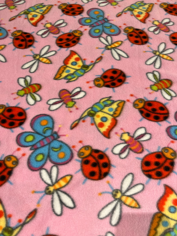 Bugs and butterflies fleece.   Sherbet colored bugs and butterflies on pink background.  58” wide, 100% polyester and $6.99 per yd.