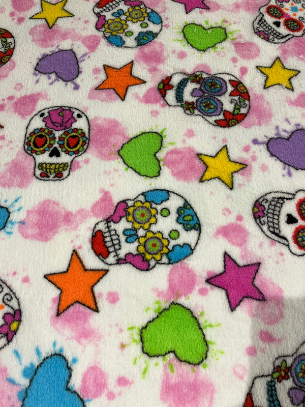 Skull candy on white background with pink accents.    100% polyester, 60” wide and $9.99 per yd.