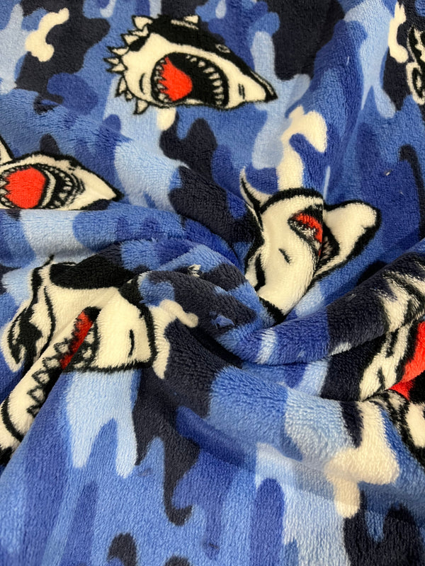 Shark attack whisper fleece.   Black and white sharks on blue background.  100% polyester, 60” wide and $9.99 per yd