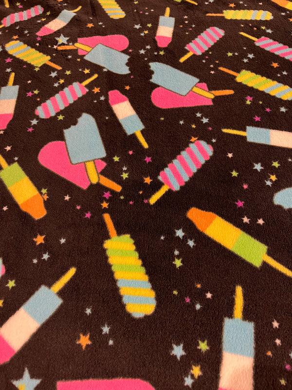 Ice cream whisper fleece.  Bright colored ice cream in black background.  100% polyester, 60” wide and $9.99 per yd