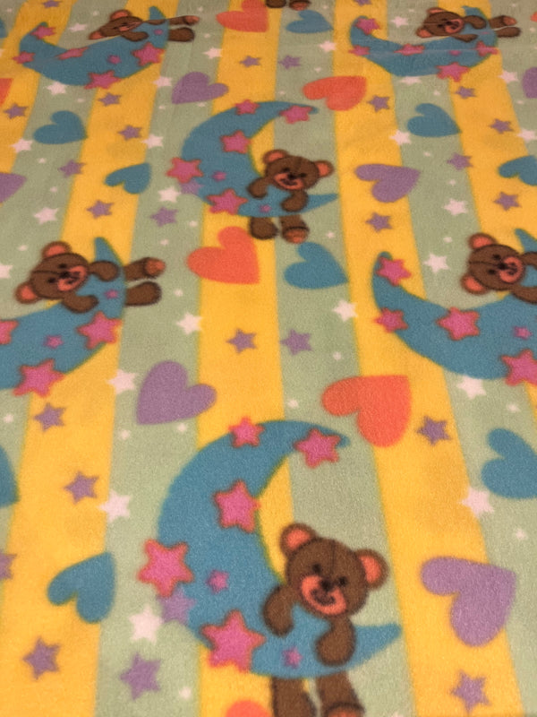 Good night bear fleece.  Sherbet colors adorn teddy hanging on a turquoise moon.  60” wide, 100% polyester and $6.99 per yd